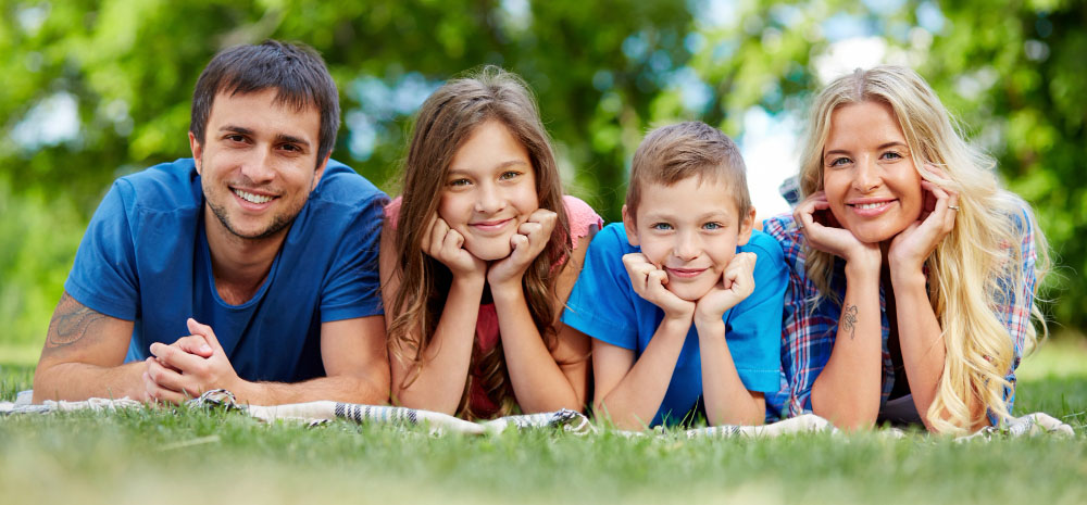 Happy family laying in the grass.