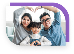 Parents and a child sit together and make heart signs with the hands and arms.
