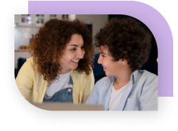 A child smiles while talking to an adult.