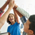 Kids in a circle giving high fives all at once.