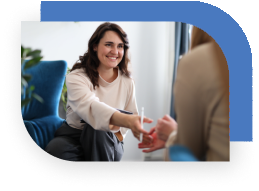 A therapists reaches toward a patient's hand.