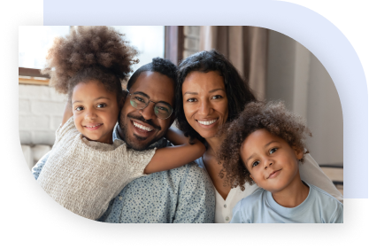 A happy family with two girls sitting close together and smiling.