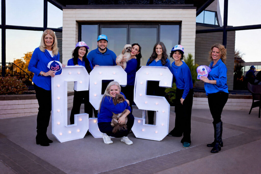 Image of the current CSS Dallas staff standing together in front of big CSS letters.